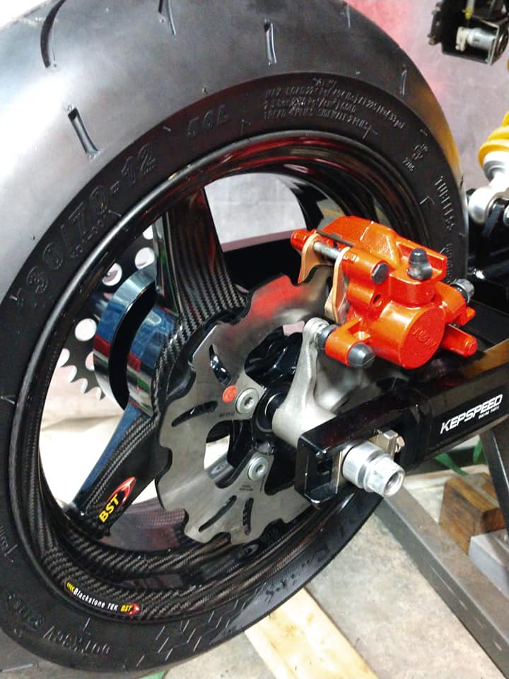 BST carbon fiber rear wheel with orange Brembo caliper and Kepspeed axle block installed on the Grom