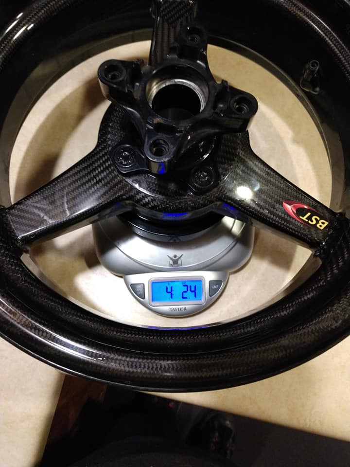 BST Blackstone Tek 3-spoke carbon fiber wheel sitting on a Taylor kitchen scale displaying 4.24 lbs