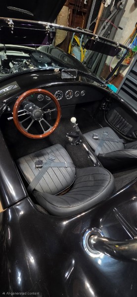 Jim's Cobra kit car cockpit — wood-rim billet steering wheel, chrome gauges, quilted black leather seats, chrome shifter